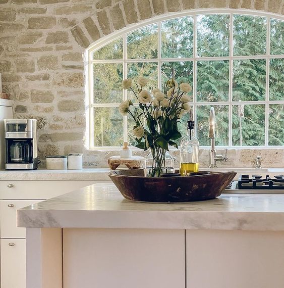 a bowl with flowers sitting on top of a kitchen counter