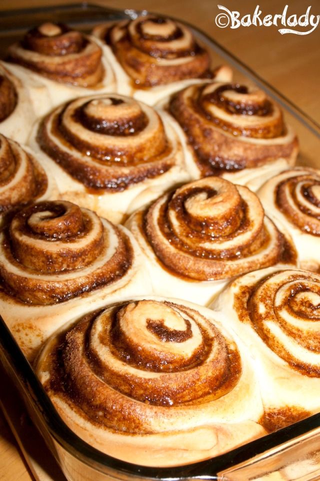 cinnamon rolls in a glass baking dish on a wooden table