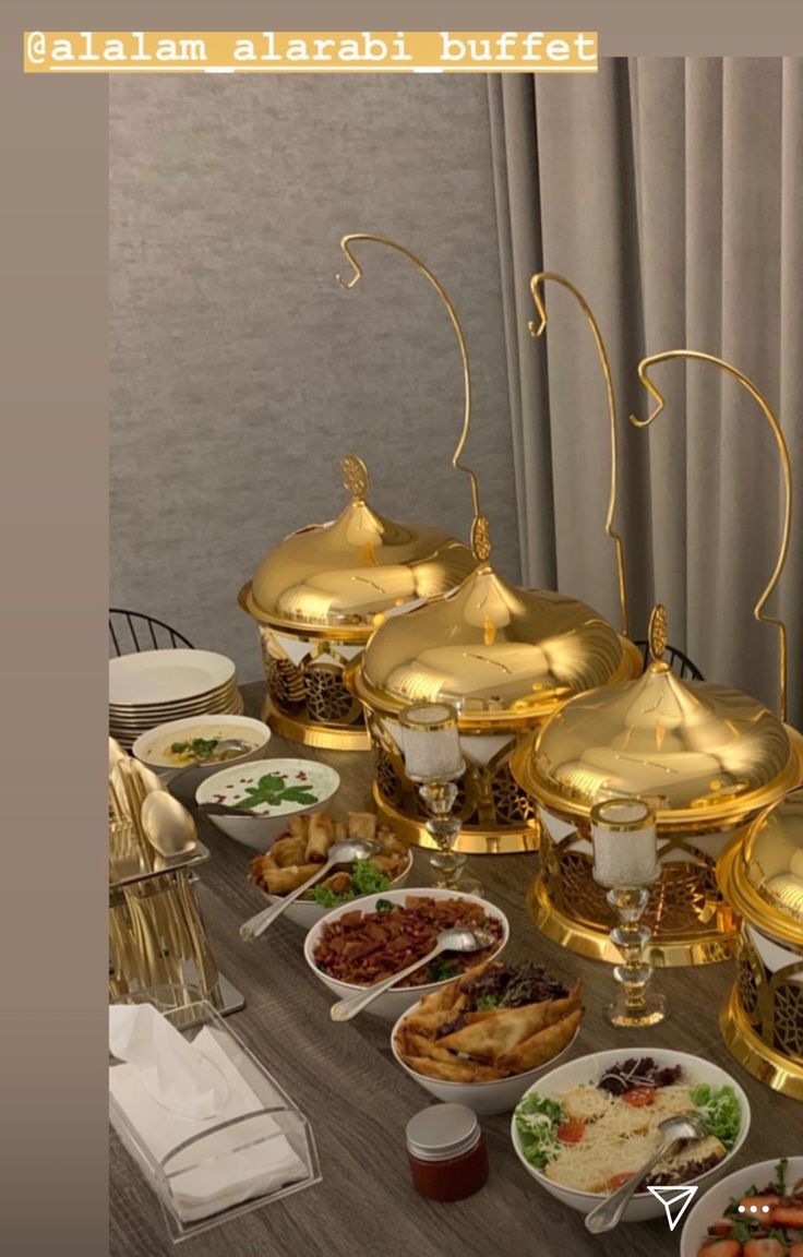 a table filled with lots of different types of food on plates and serving utensils