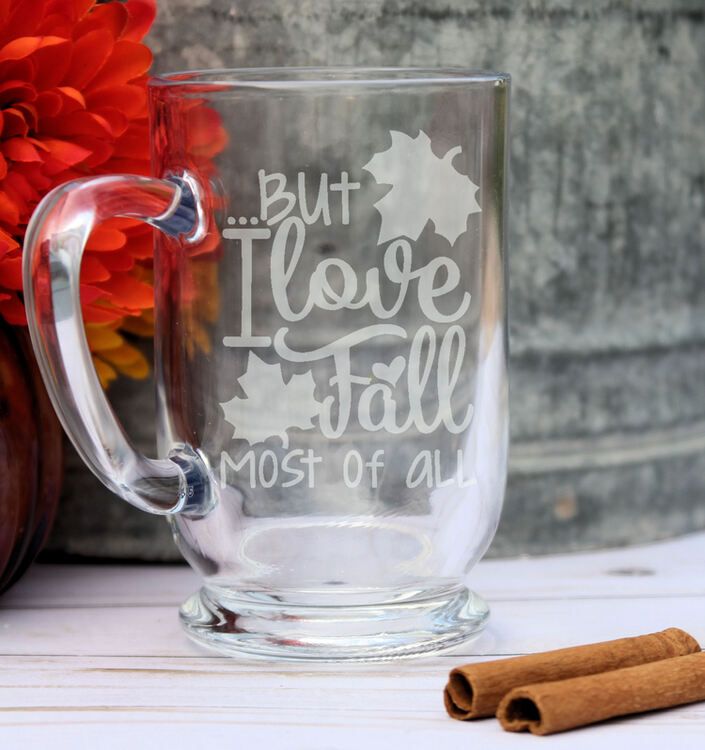 a glass mug with the words but i love fall most of all written on it