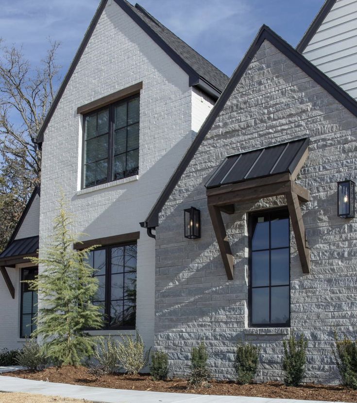 a white brick house with black windows and shutters