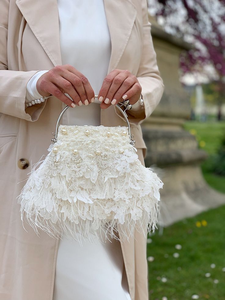 Elegant and vintage-looking light ivory wedding clutch is handmade and decorated with airy Italian lace and lovely chantilly Frech lace, pearl beads, seed beads, and finished with white ostrich feathers. The small whimsical bridal purse will be a great addition to your amazing look on the Special Day! The tiny fancy evening bag will be a lovely accessory not only for the bride but also will suit the bridesmaids' outfit, Mother of the bride, or Mother-in-law festive look. And after the celebration is over - you can take it with you to the costume party in Great Gatsby style, or date as an extraordinary stylish accent! 🤍Dimensions of the kiss lock bridal bag: 8"x6.5 '', with handle - 10"x8.5" / 20cm x 17cm, with handle - 20cm x 22 cm 🤍The weight of the bedazzled handbag is 0,88 lb (400 g) Great Gatsby Fashion, Bridal Purse, Bridal Bag, Ivory Flower, Wedding Purse, Wedding Clutch, Light Ivory, Ivory Flowers, Flower Bag