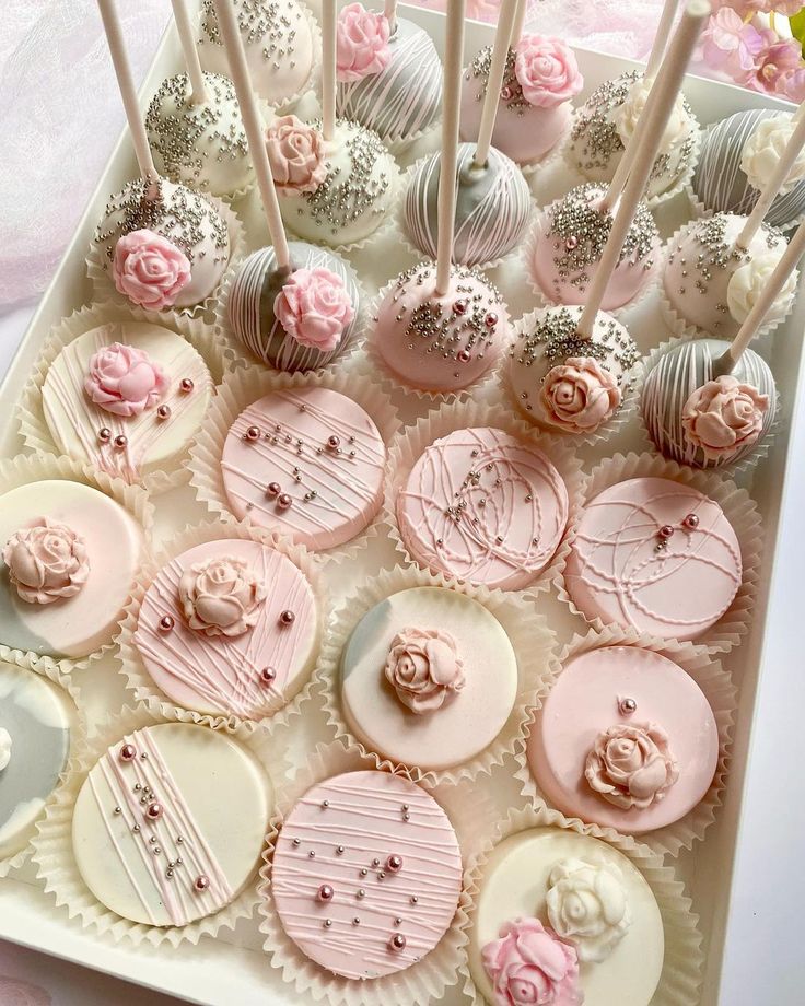 a box filled with lots of pink and white cupcakes on top of a table