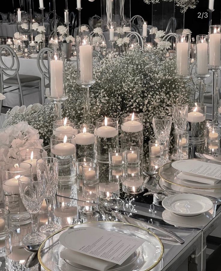 the table is set with candles, plates and silverware for an elegant wedding reception