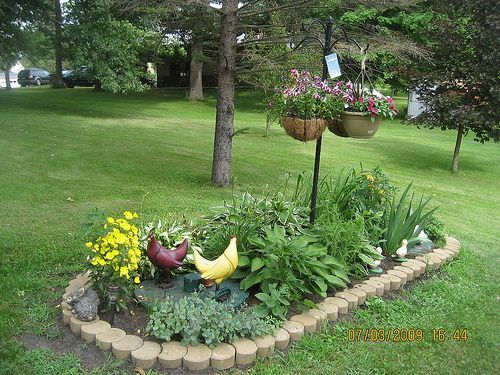 a flower garden in the middle of a lawn