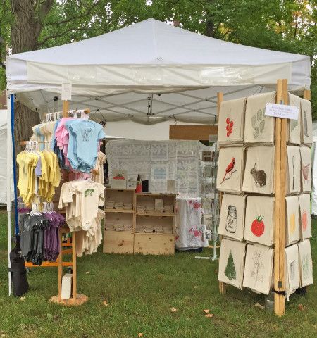 an outdoor market tent with clothes on display