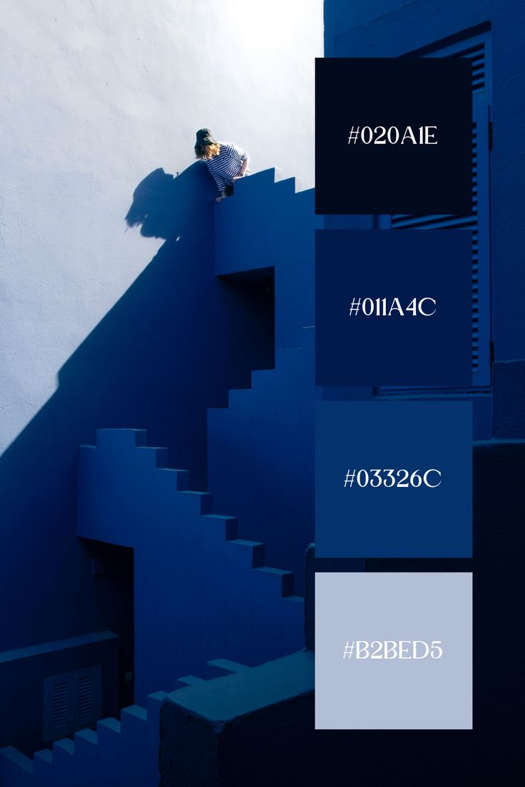 a man climbing up the side of a building with blue paint swatches on it