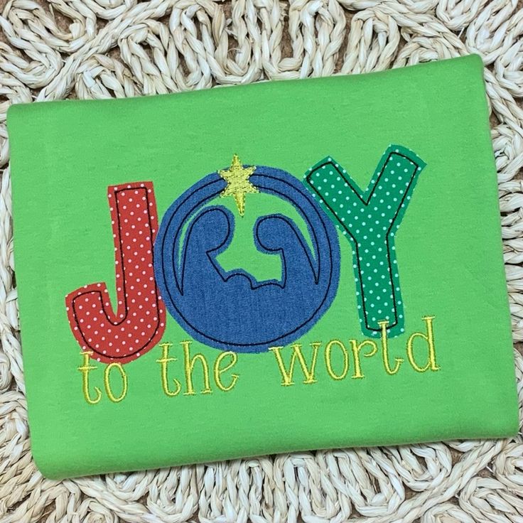 a green shirt with the word joy to the world on it and a star in the middle