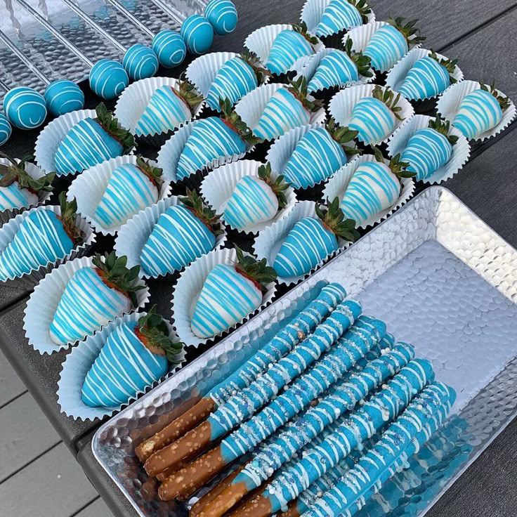 blue desserts and strawberries are on display at a party or gathering for people to eat