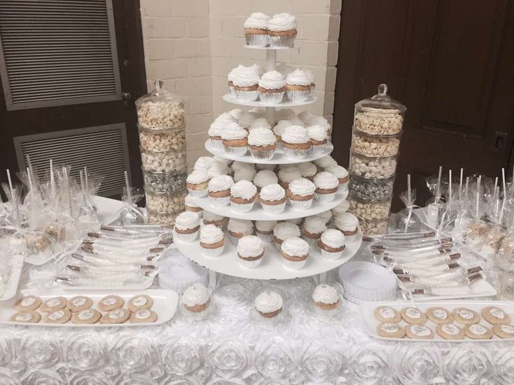 a white table topped with lots of cupcakes