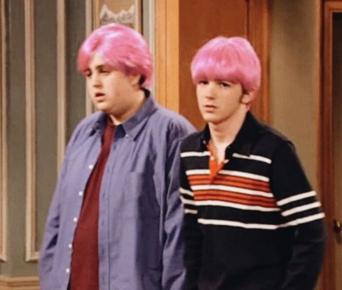 two men with pink hair standing next to each other