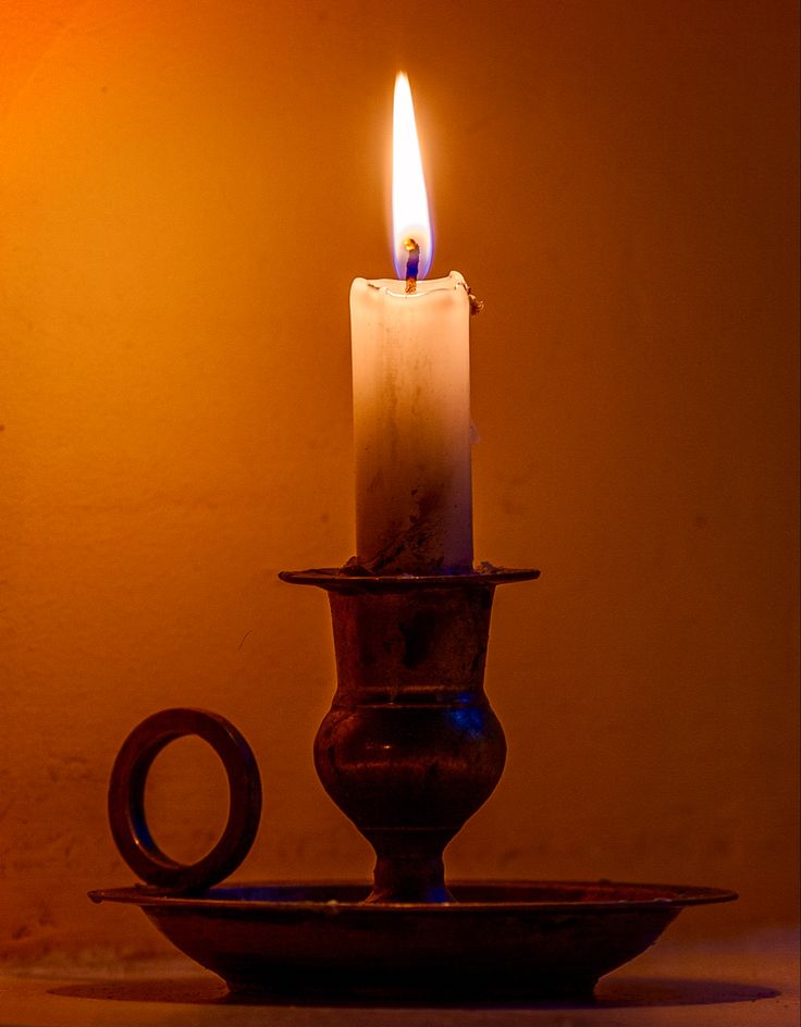 a lit candle sitting on top of a plate