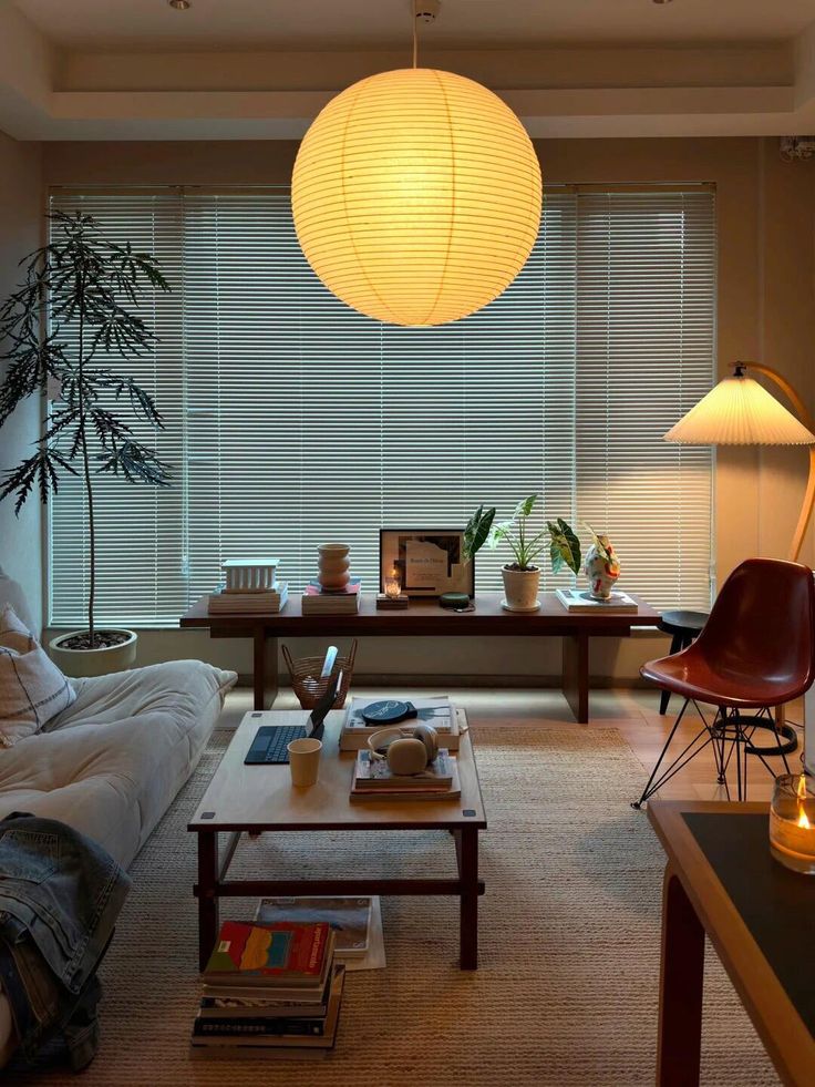 a living room filled with furniture and a lamp hanging over the top of a table