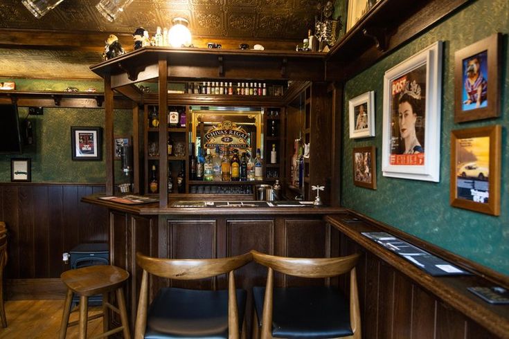 a bar with several stools and pictures on the wall