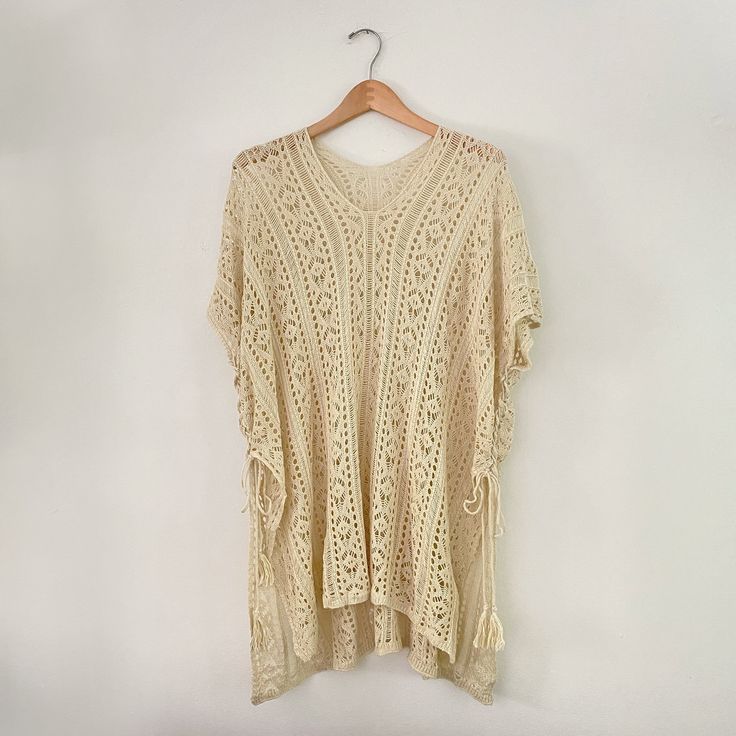 "Knit lightweight beach dress. Short sleeve. Sides lace up. Drapey, loose fit item. Pre-loved item. Good vintage condition. Brand: unknown. Size on tag: XL Chest: up to 66\" Length: 31\" in front, 35\" in back Please allow 0.5\" margin of error for measurements, they are taken by hand. Material: 100% polyester Wash: Machine wash warm. Tumble dry low. Made in: China" Casual Beige V-neck Cover-up, Beach Dress With Drawstring And Short Sleeves, Short Sleeve Drawstring Beach Dress, Bohemian V-neck Crochet Dress For Day Out, Beige Crochet Dress For Beach Cover-up, Casual Crochet Dress With Short Sleeves For Summer, Bohemian Lace Beach Dress, Bohemian Crochet Lace Beach Dress For Summer, Bohemian Summer Beach Dress With Crochet Lace