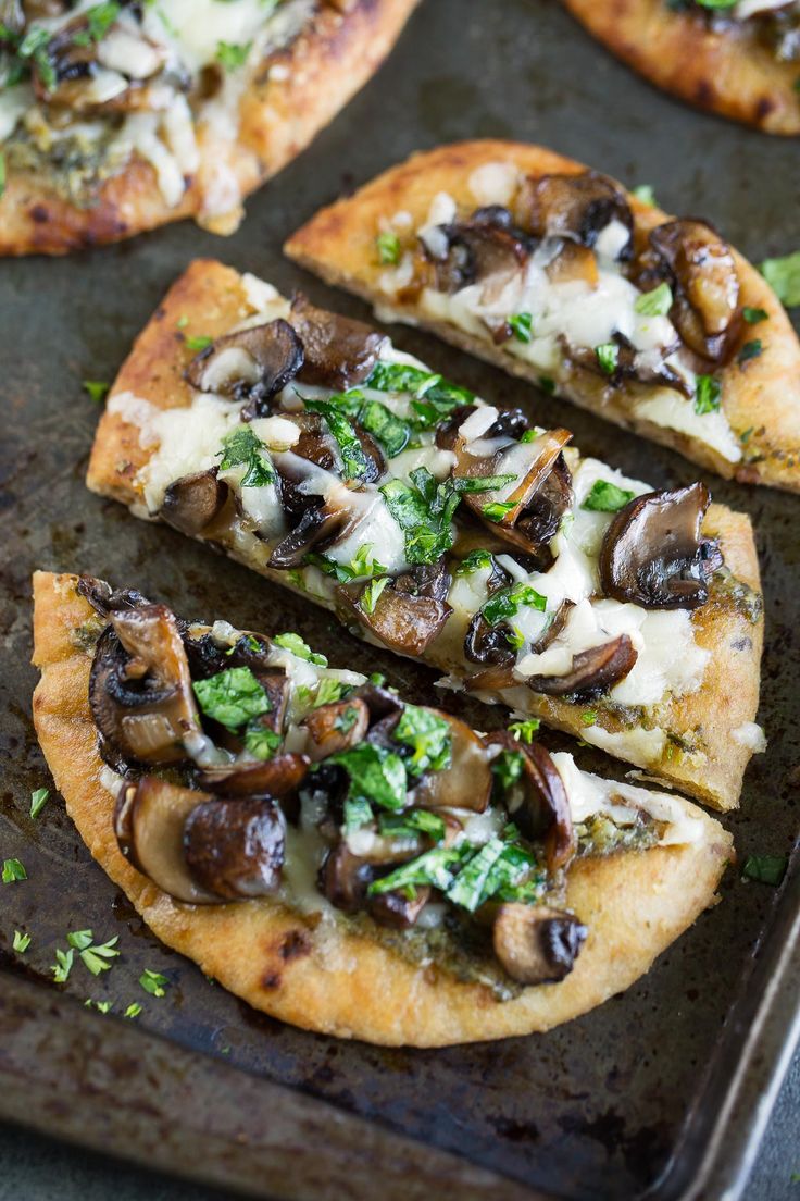 several slices of pizza with mushrooms and cheese on a baking sheet, ready to be eaten