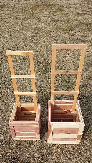 two wooden planters sitting on top of a grass covered field next to each other