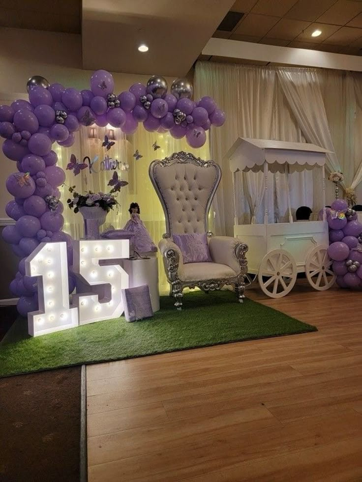 a decorated stage set up with balloons and chairs for the number fifteen birthday party in purple