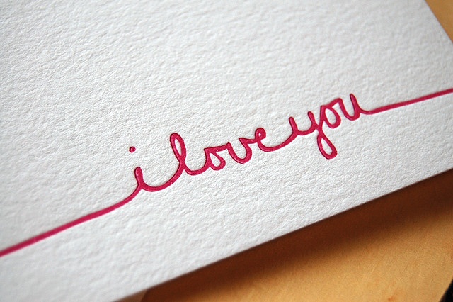 the word i love you written in red ink on white paper