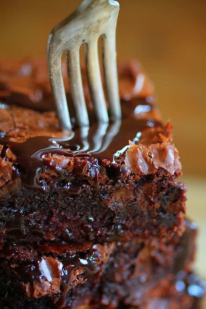 a fork sticking into a piece of chocolate cake