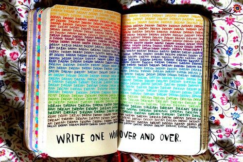 an open book sitting on top of a bed covered in colorful sheets and pillows, with the words write one word and over it