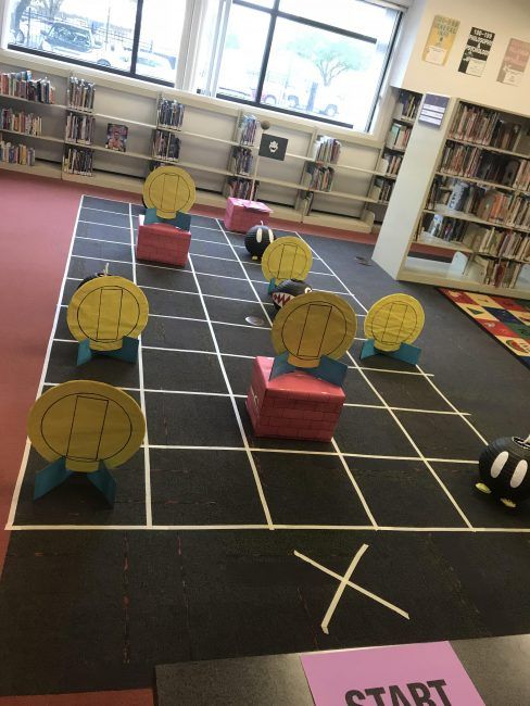 some kind of game in the middle of a library with balls and sticks on it