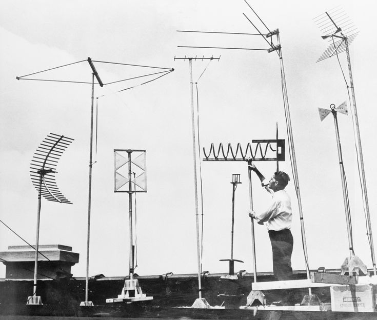 black and white photograph of man working on antennas