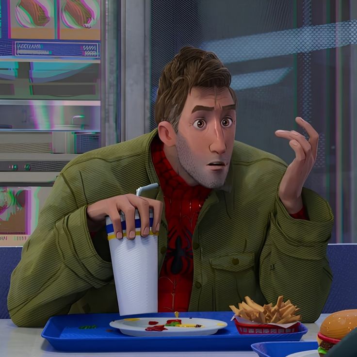 a man sitting at a table in front of a plate of fries and a drink