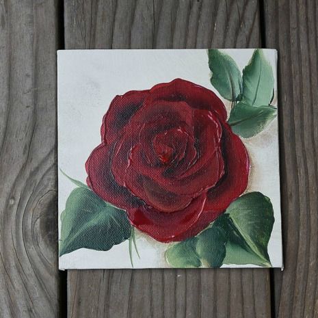 a painting of a red rose with green leaves