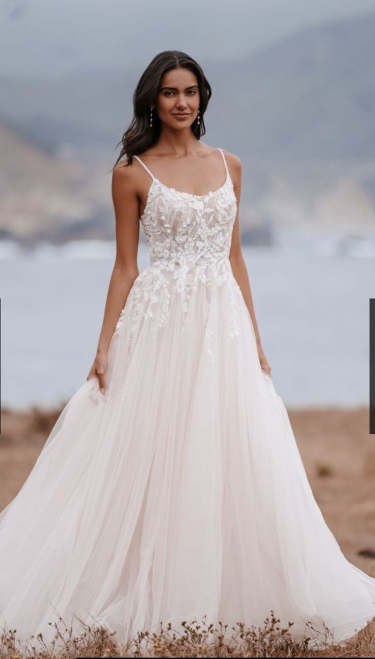 a woman in a wedding dress standing on the beach