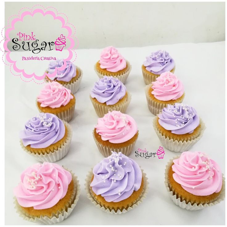 cupcakes with pink and purple frosting are arranged on a white tablecloth