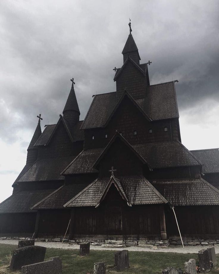 an old wooden church with steeples and crosses on the front, surrounded by tombstones