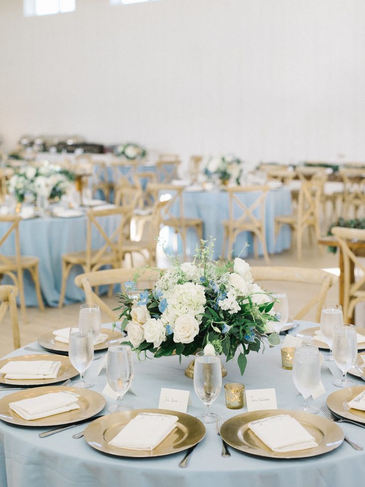 the tables are set with white and blue flowers