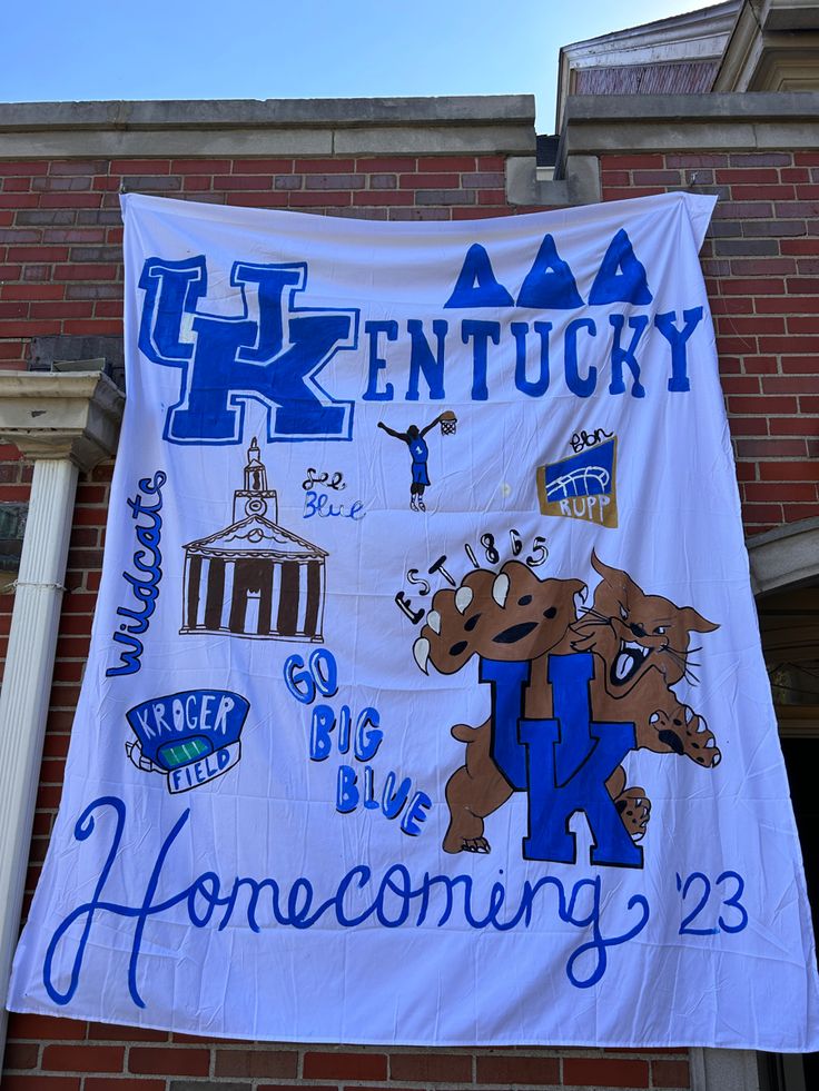 a banner hanging from the side of a brick building that says kentucky and features images of dogs