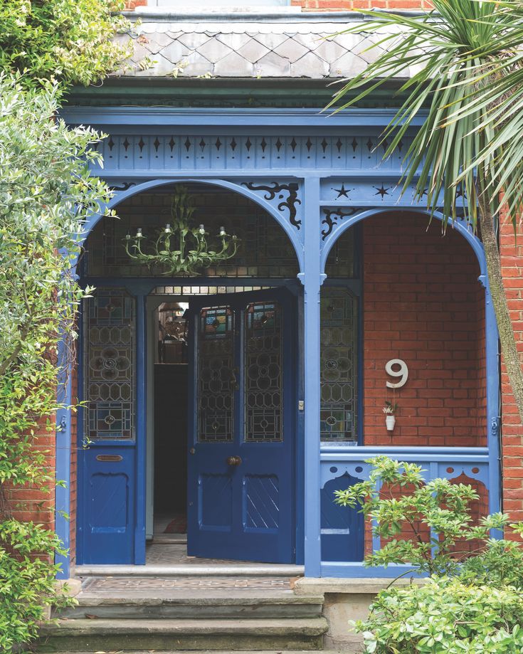 a blue building with a chandelier hanging from it's ceiling and doors