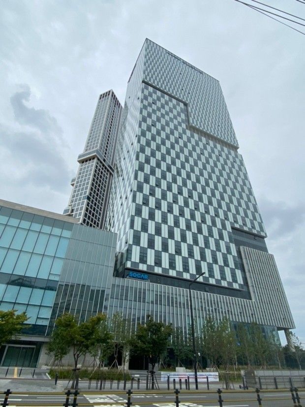 a tall building with many windows on the side of it's face in front of a cloudy sky