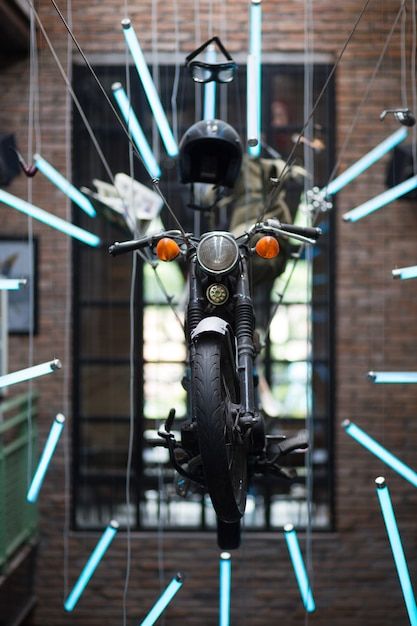 a motorcycle parked in front of a building with lights hanging from it's ceiling