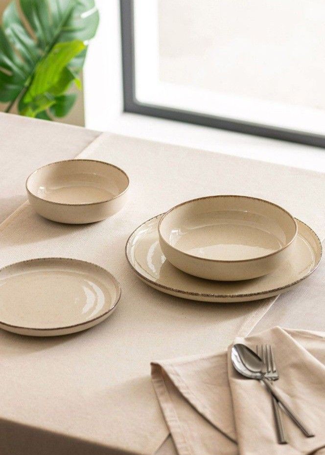 the table is set with three plates and two silverware on it, along with a napkin