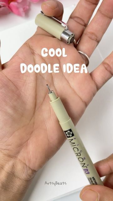 a hand holding a pen with the words cool doodle idea written on it