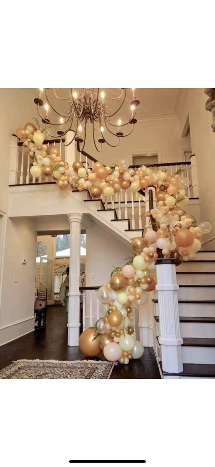 a staircase decorated with gold and white balloons