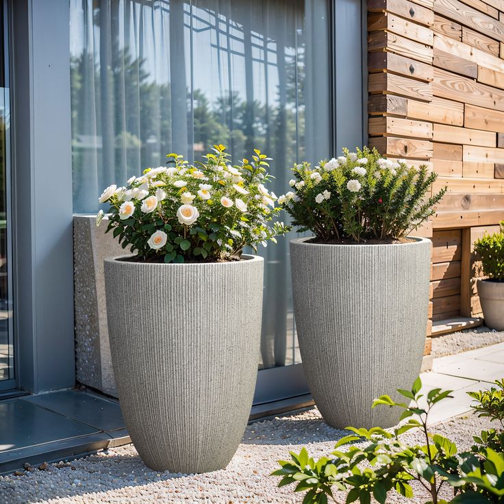 two large planters sitting next to each other in front of a building with windows