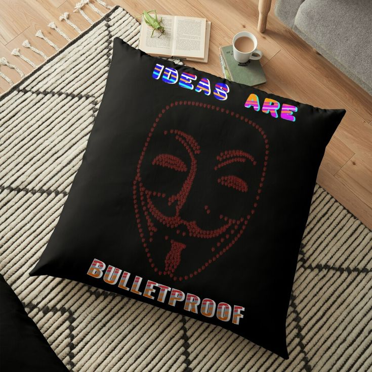 a black floor pillow with the words, ideas are bulletproof on it and a red mask