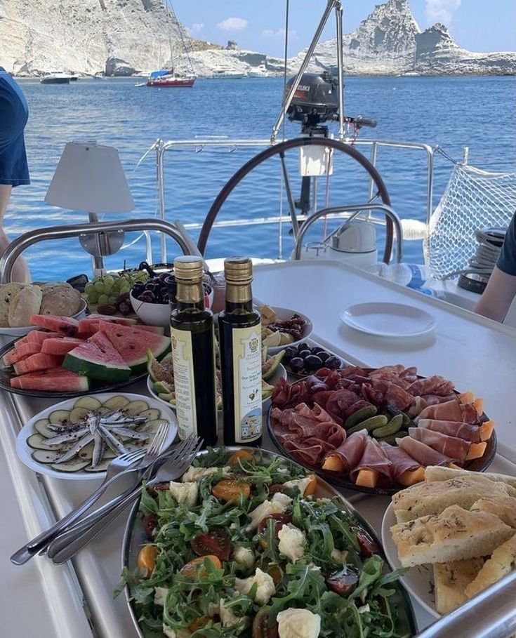 a table filled with lots of food on top of a boat