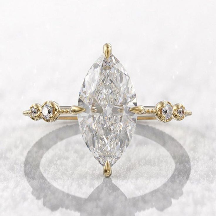 a pear shaped diamond ring with three small diamonds on the band and an oval center stone