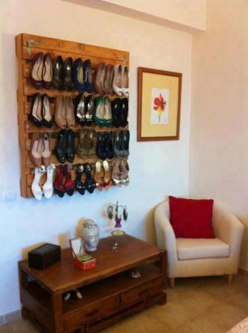 two chairs and a table in a room with shoes on the wall behind them,