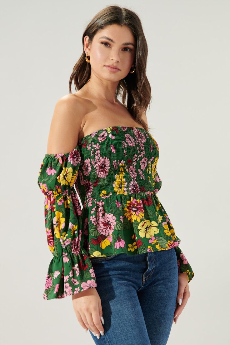 Autumn is in full bloom in the Everly Floral Off the Shoulder Smocked Peplum Top. Perfect for warmer autumn days, this top features a smocked bodice with a peplum waist. Smocked off the shoulder sleeves are attached. Complete the look with light wide leg pants and strappy heels for a flirty look.- Smocked bodice- Off the shoulder- Smocked sleeves- Peplum- Color: Green MultiSize + Fit - Model is 5'9" and wearing size XS- Measurements taken from size S - Chest: 29"- Length: 31 1/2" fabricSelf: 100 Off-shoulder Top With Smocked Bodice For Fall, Smocked Cuffs Tops For Day Out In Fall, Smocked Cuffs Tops For Fall Day Out, Long Sleeve Tops For Garden Party, Tops With Smocked Cuffs For Fall Day Out, Fall Tops With Smocked Cuffs For Day Out, Bohemian Peasant Top With Elastic Sleeves For Spring, Summer Top With Smocked Bodice For Garden Party, Summer Garden Party Top With Smocked Bodice