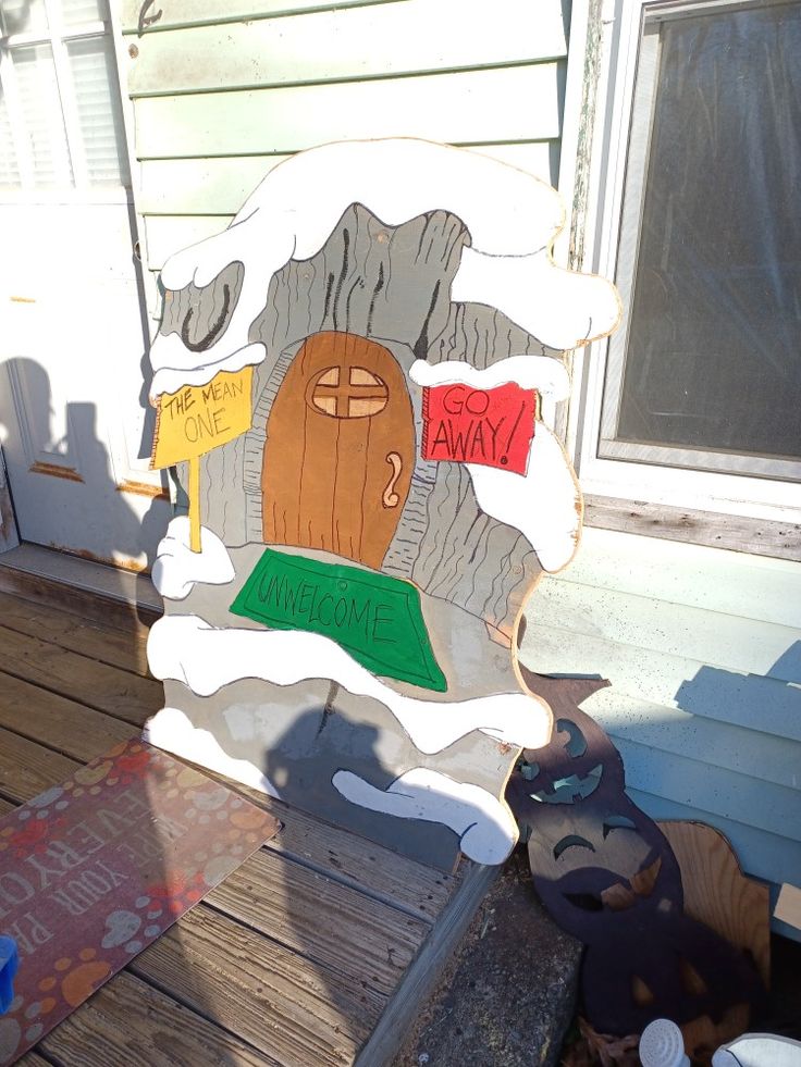 a wooden sign sitting on top of a wooden deck next to a building with windows