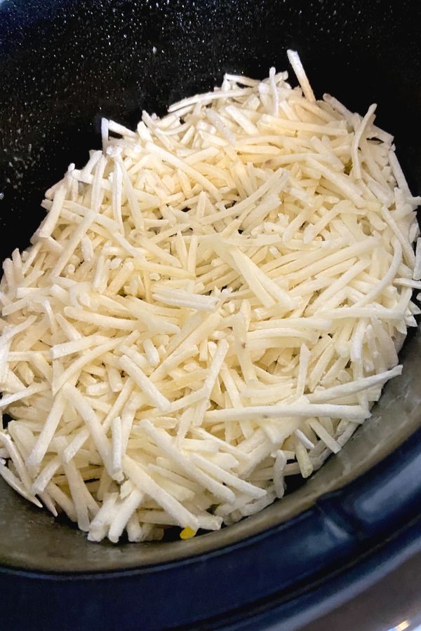 shredded cheese in a slow cooker being cooked