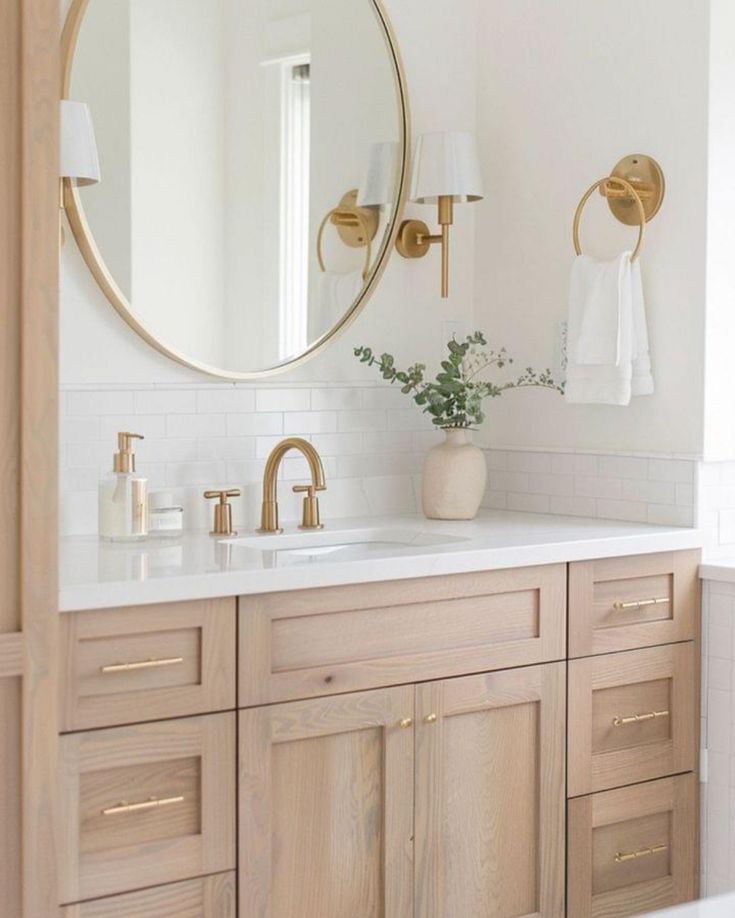 a bathroom sink with a large round mirror above it