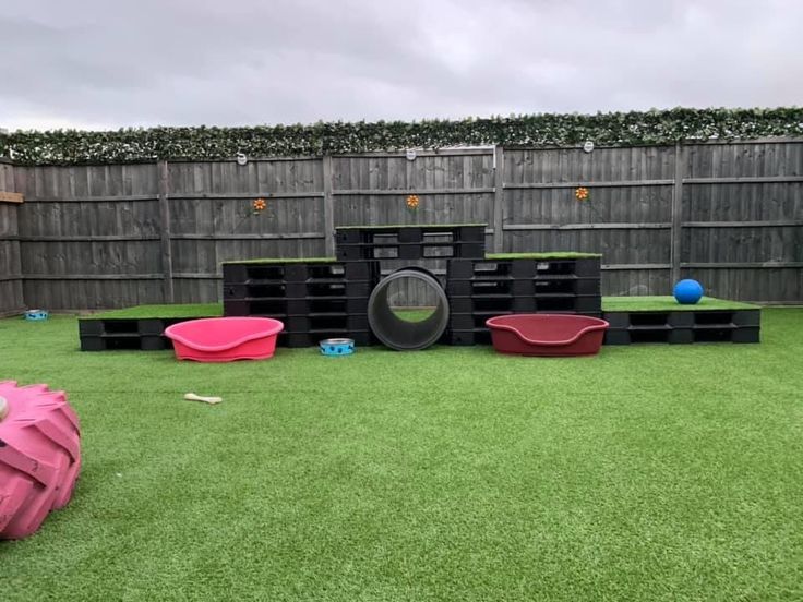 an outdoor play area with artificial grass and toys